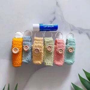 Handmade crochet lip balm holders with wooden button and keyring loop in assorted pastel colours