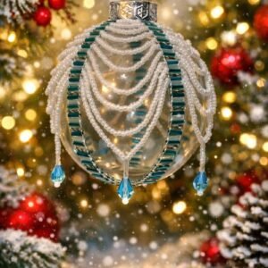 Handmade beaded Christmas bauble with white pearl beads, teal accents and blue crystal drops hanging on a decorated Christmas tree