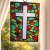 Handmade stained glass effect cross suncatcher with colourful red, green and turquoise resin panels hanging in a sunlit window